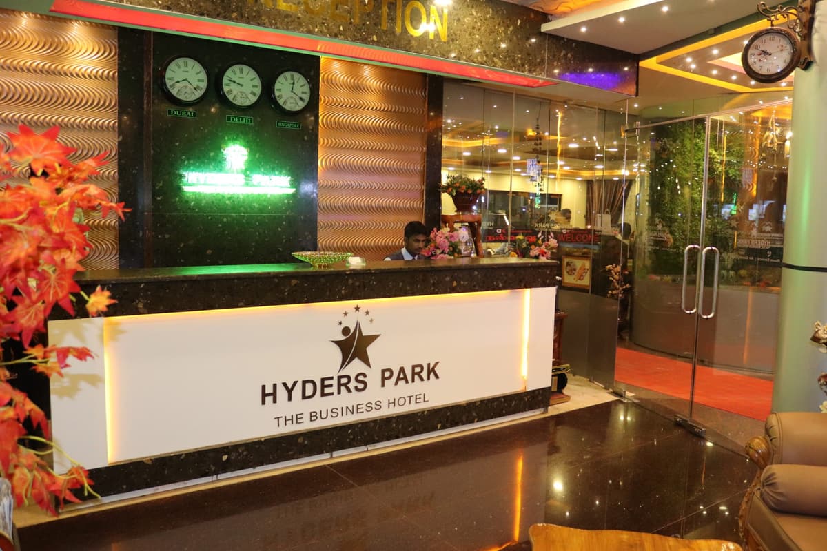The Hyderspark reception desk, backlit beneath world clocks and the hotel's star emblem