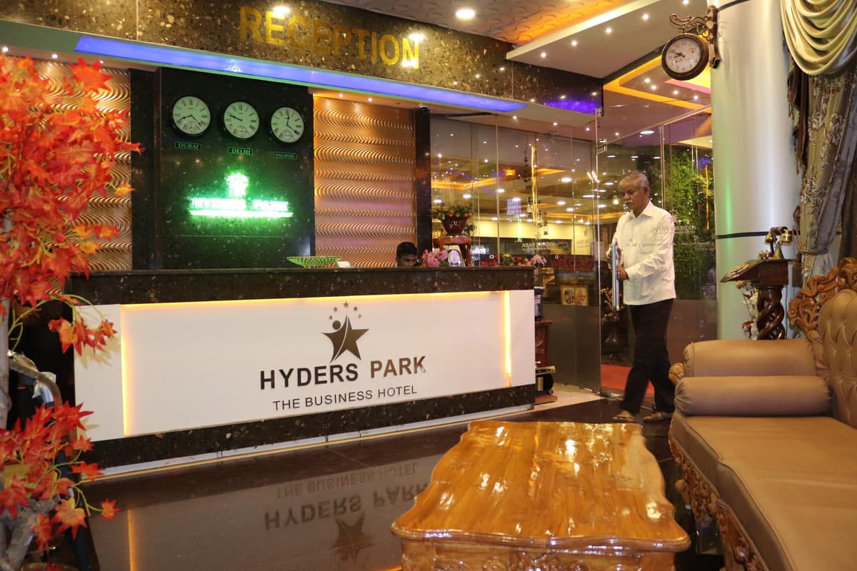 Reception at Hyderspark, with the illuminated logo desk and a staff member welcoming guests