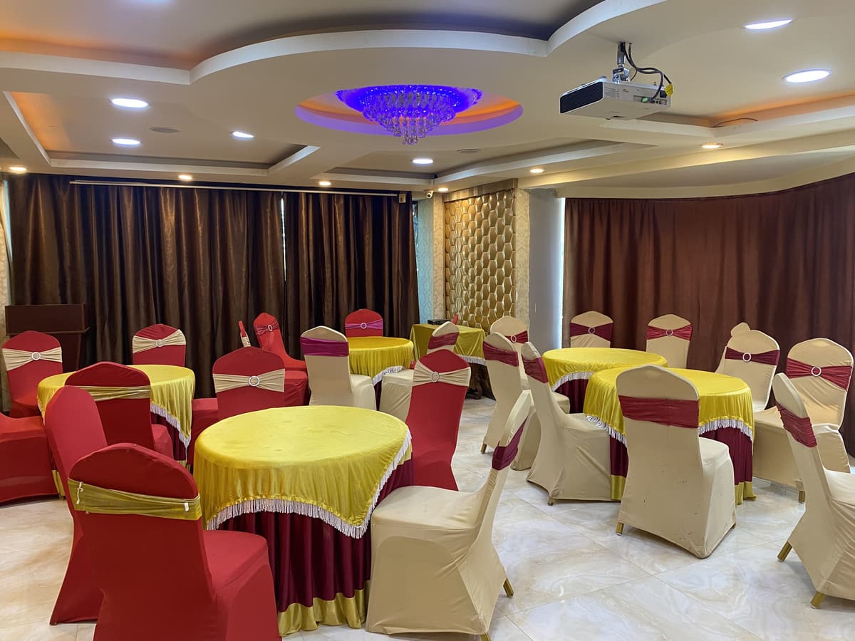 The Jasmin hall set with round tables, gold covers and red chair sashes