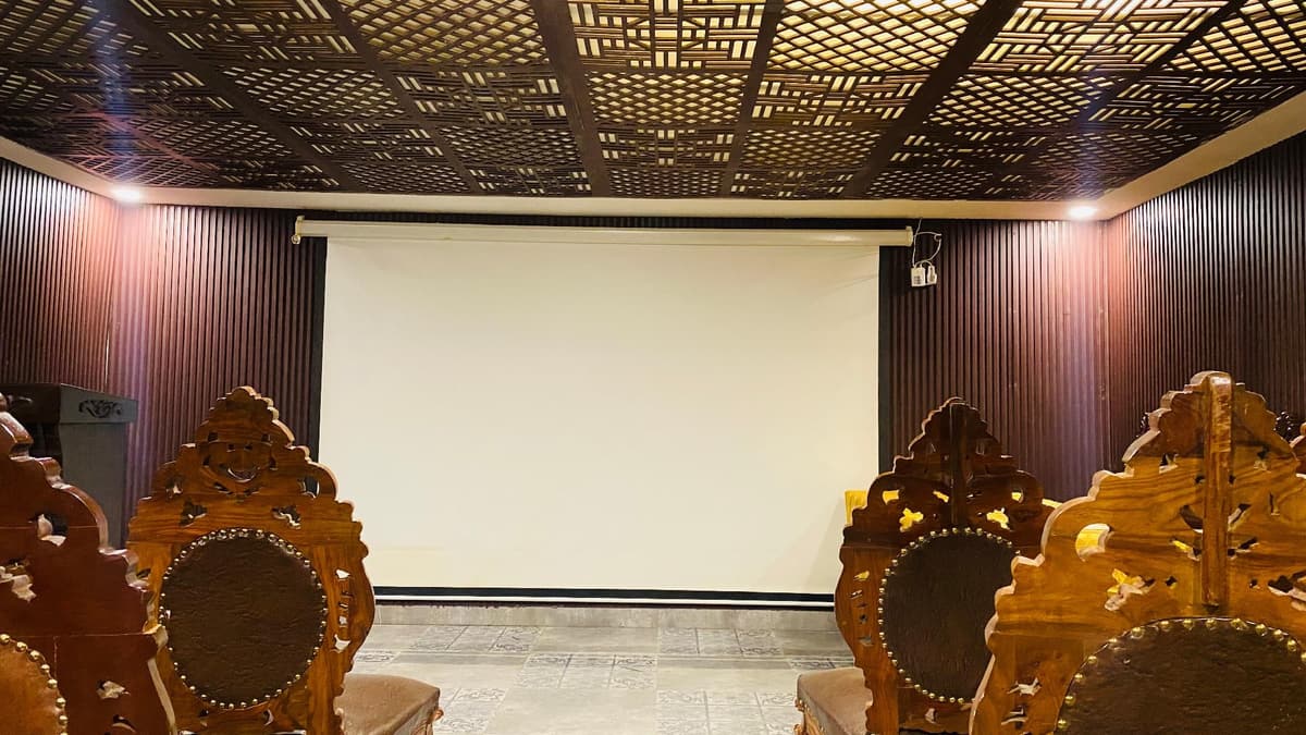 Carved chairs facing the projection screen in the Jasmin hall