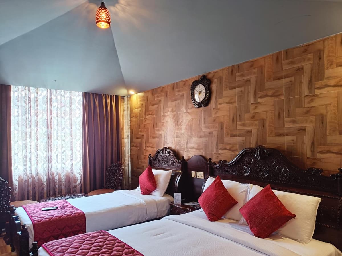 Park Grand room with a double bed and a single bed under a wall clock