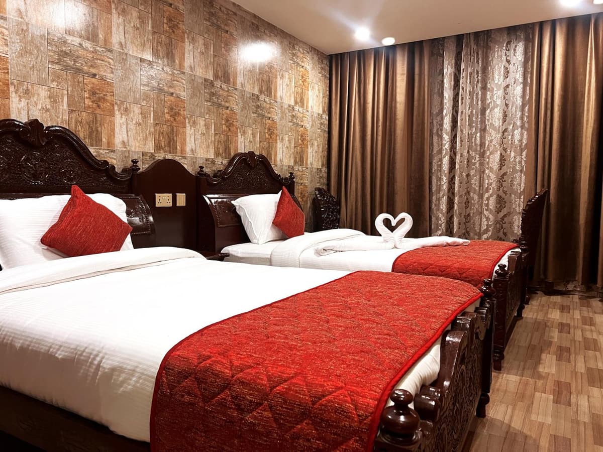 Park Queen room with twin beds, red bed runners and a carved wooden headboard
