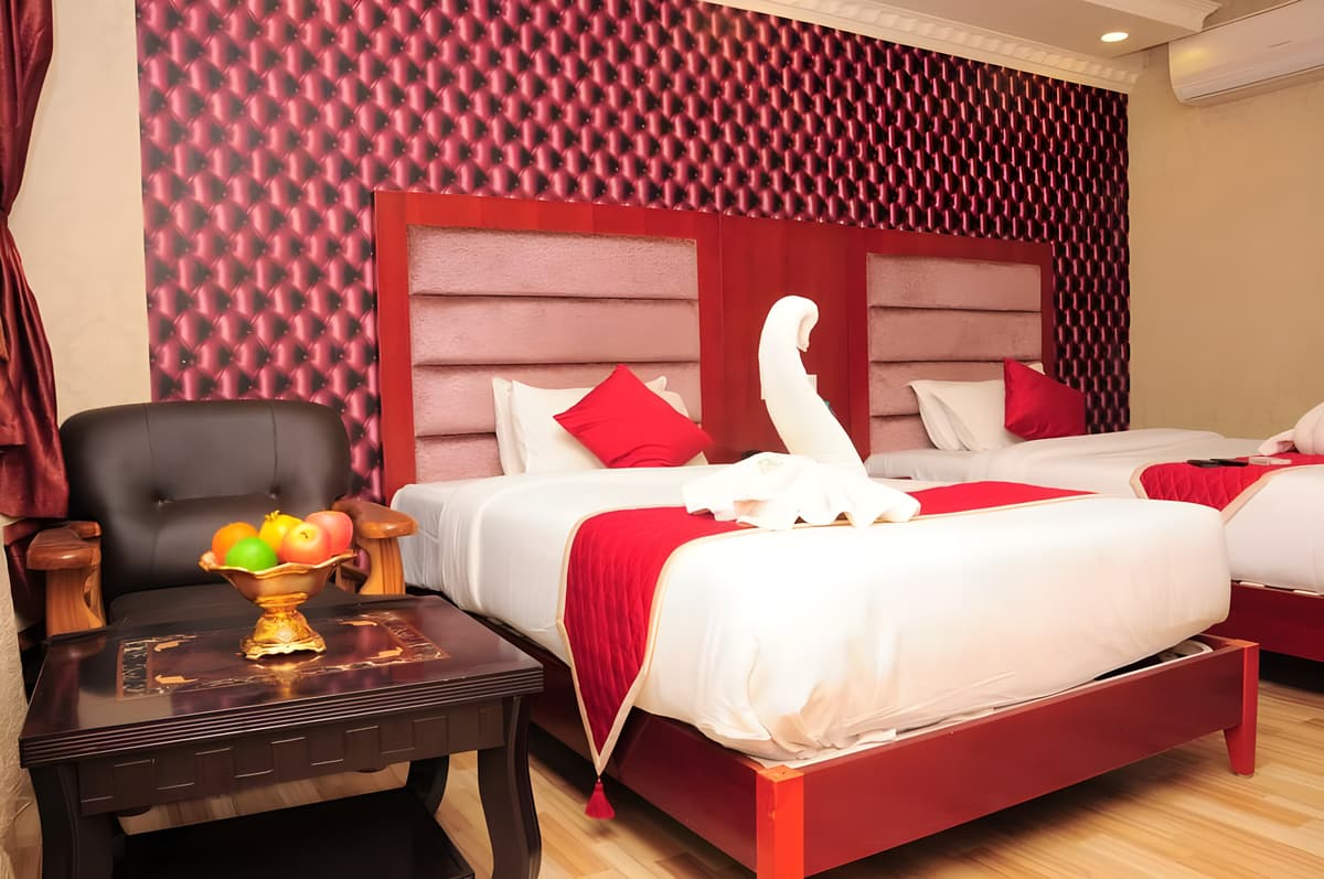 Park Castle room with two beds, a towel swan and a tea table with a fruit bowl
