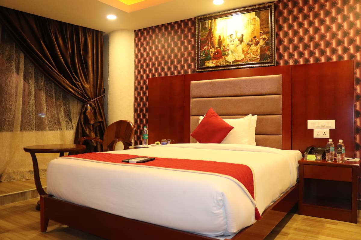 Park King room with a large bed, upholstered headboard and framed painting