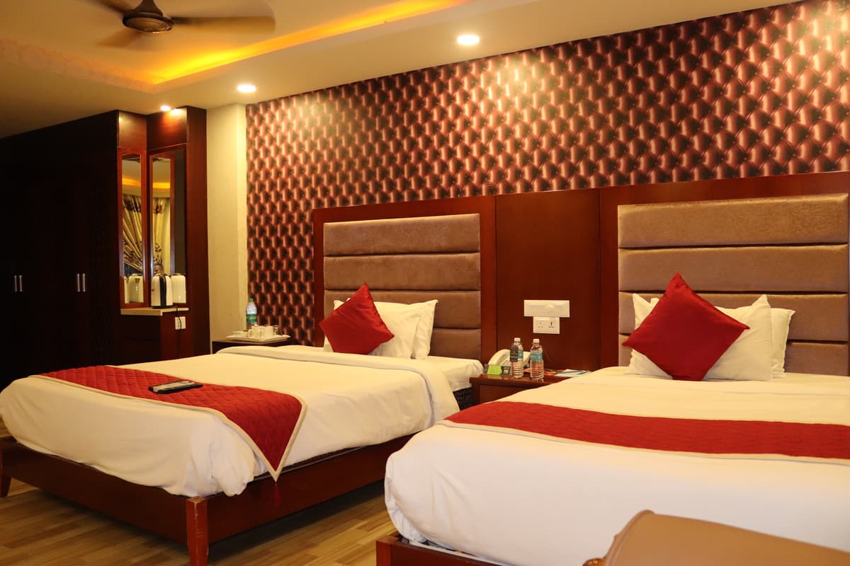 Park Suite with two made-up beds, red accent cushions and a wooden wardrobe